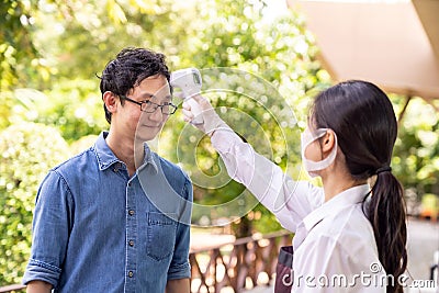 New normal Waitress take temperature customer Stock Photo