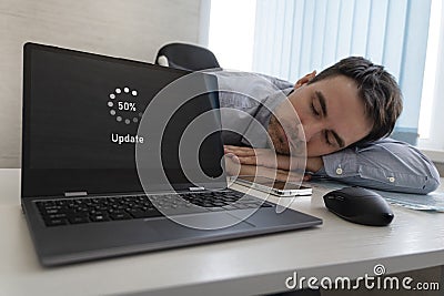 A new operating system update. software is in process of updating. The employee is tired and sleeps on the desktop. long wait Stock Photo