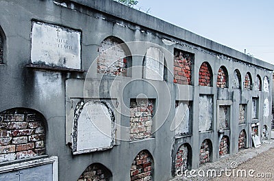 New Orleans, ancient cemetery, wall of niches, tombs, bricked up, some with plaques Editorial Stock Photo