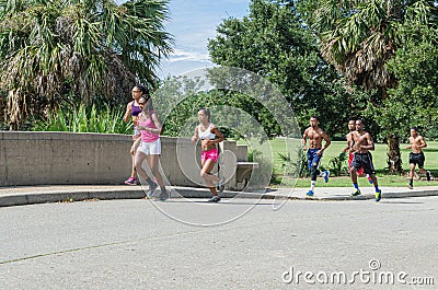 Girls and Boys Running in City Park Editorial Stock Photo