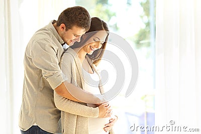 New parents looking at belly of pregnant mother Stock Photo