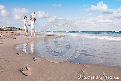New Parents Play with Baby on the Beach Stock Photo