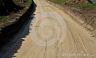 A new path through the fields. an excavator and a grader drove the way through a spade and rolled the topsoil into piles and a rec Stock Photo