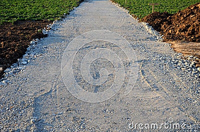 A new path through the fields. an excavator and a grader drove the way through a spade and rolled the topsoil into piles and a rec Stock Photo