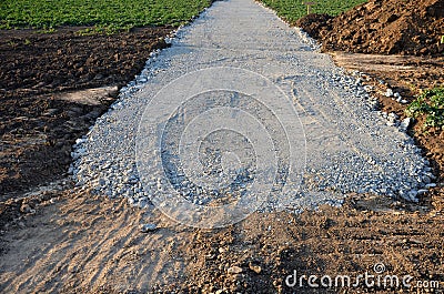 A new path through the fields. an excavator and a grader drove the way through a spade and rolled the topsoil into piles and a rec Stock Photo