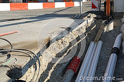 New pipes laid in a civil engineering shaft in the street with vertical and horizontal barrier planks Stock Photo