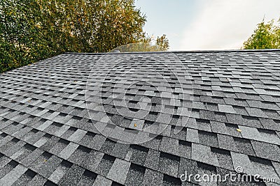 new renovated roof covered with shingles flat polymeric roof-tiles Stock Photo