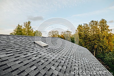 new renovated roof covered with shingles flat polymeric roof-tiles Stock Photo
