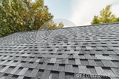 new renovated roof covered with shingles flat polymeric roof-tiles Stock Photo