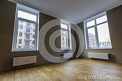 New renovated room interior with big windows, heating radiators Stock Photo