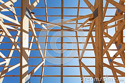 New residential wooden construction home framing against a blue sky. Stock Photo