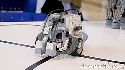 New robot project. Driving over the black tape. Self control with path detector. Electric vehicle robot on wheels during Stock Photo