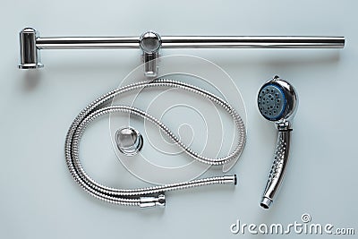 New set steel shower head sprayer with metal hose for bathroom power regulator on grey background. Repair plumbing Stock Photo