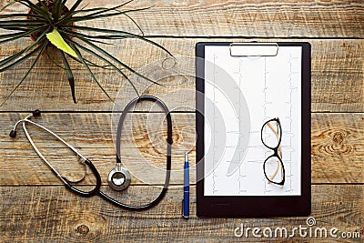 New stethoscope on wooden table with cardiogram isolated Stock Photo