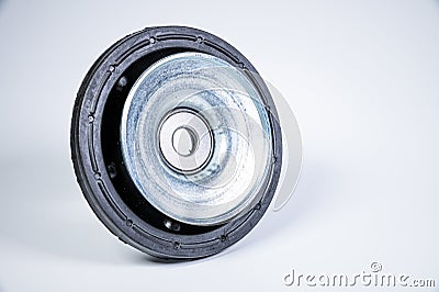 New thrust bearing of front suspension strut of a car on a gray background. The concept of new spare parts and Stock Photo