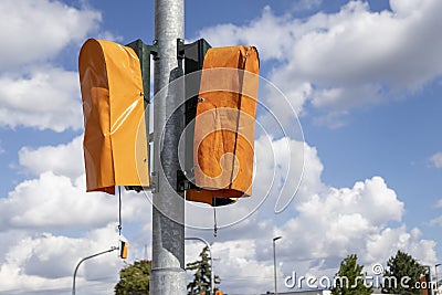 New traffic lights covered with orange plastic bags Stock Photo