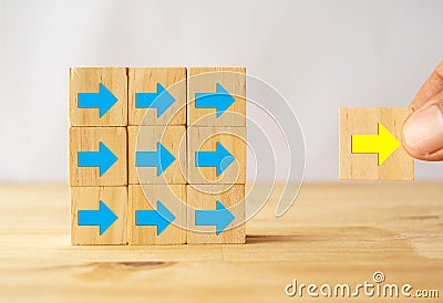New trend concept, hand move forward the yellow arrow as gold goal success trend leader which follower by blue arrow on wooden tab Stock Photo