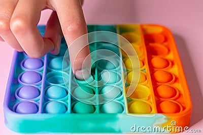 New trend sensory rainbow silicone anti-stress toy for the development of fine motor skills in children. Colorful toy simple Stock Photo