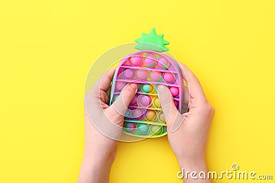 New trendy popular silicone colorful anti stress Pop It toy for child on yellow background. View from above. Stock Photo