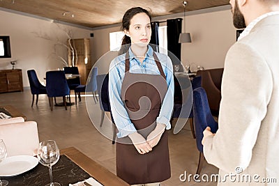 New waitress attentively listening to restaurant manager Stock Photo