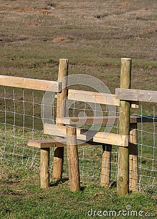 New wooden stile over wire fence in countryside Stock Photo