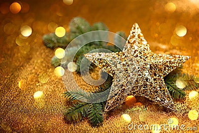 New Year card. Christmas greetings. Golden decorative star with Christmas tree branches, on golden background. Stock Photo