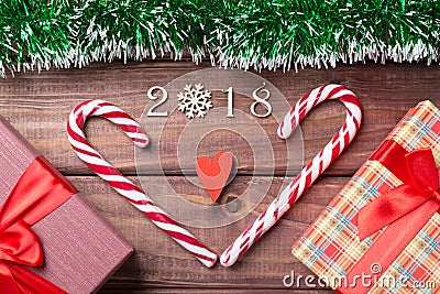 New Year or Christmas card. 2018 wooden decorative figures with heart shaped candy canes, giftboxes and red heart with green spang Stock Photo