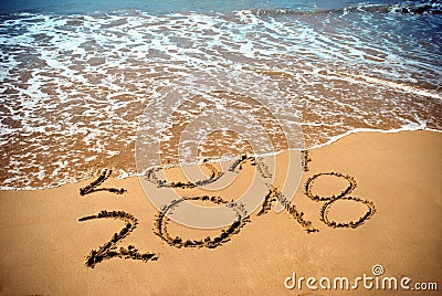 New Year 2018 is coming concept - inscription 2017 and 2018 on a beach sand, the wave is covering digits 2017. New Year 2018 celeb Stock Photo