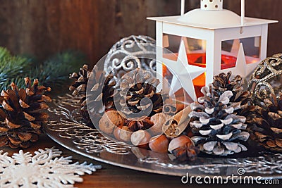 New Year composition: burning lantern, pine cones and Christmas tree decorations. Stock Photo