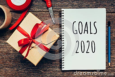 New year concept. Goals 2020 and notepad, gift box wooden table with copy space Stock Photo