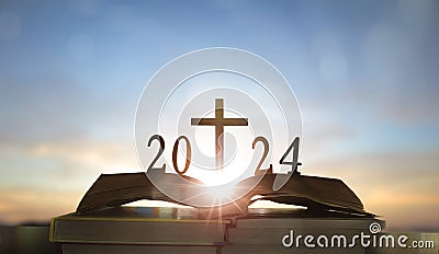 2024 new year and cross of jesus christ on open holy bible with sunrise background Stock Photo
