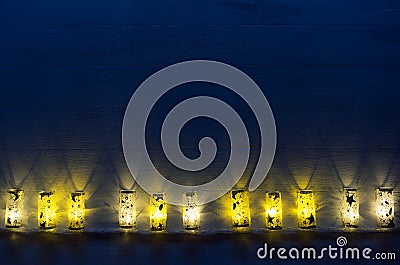 New year decor, lights burn on blue indigo wood background. Stock Photo