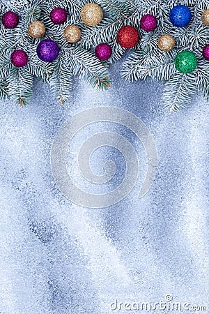 New year decorations on gray grunge board, festive background with fir branch and shiny balls. Postcard with Christmas tinsel. Stock Photo