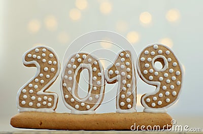 New Year 2019. Gingerbread figures on a wooden board. Christmas lights on the background. New Year greetings. Suitable as a backg Stock Photo