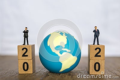 2020 New year , Global and Business concept. Close up two businessman miniature figure people standing on top of stack of wooden Stock Photo