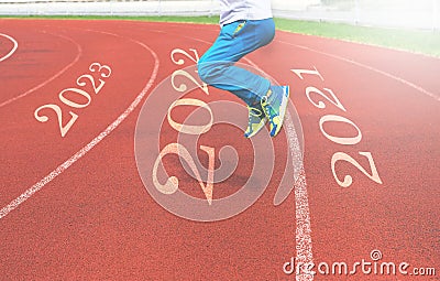 The child`s feet jump from 2021 to 2022 on the treadmill Stock Photo