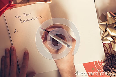 New year resolutions written with a hand on notebook with new years deco Stock Photo