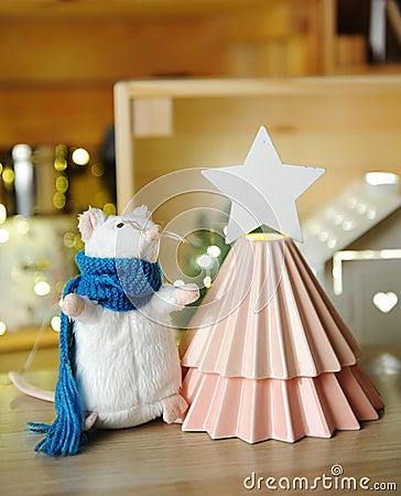 New Year decorations. Ceramic Christmas tree made from origami coffee drippers. Rat mouse in scarf. Garland lights Stock Photo