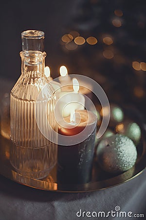 New Year`s still life. Glasses and a decanter from transparent glass, candles and golden xmas ball Stock Photo