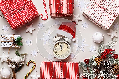 New Year`s winter composition. Alarm clock santa hat Christmas boxes with gift fir branches on a white background. Stock Photo