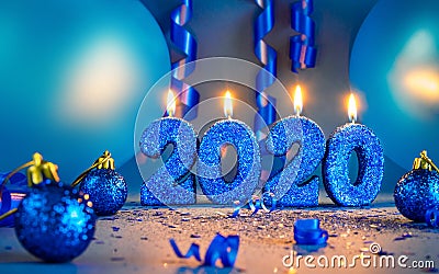 New years 2020 blue glitter candals with balloons and streamers Stock Photo