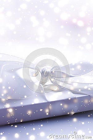 Winter holiday gift and glowing snow background, Christmas presents surprise Stock Photo
