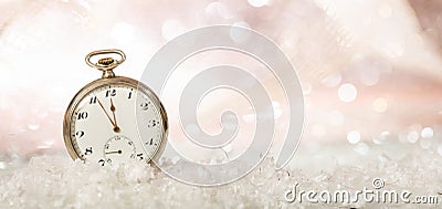 New Years eve party celebration. Minutes to midnight on an old fashioned pocket watch, bokeh snowy background, copy space Stock Photo