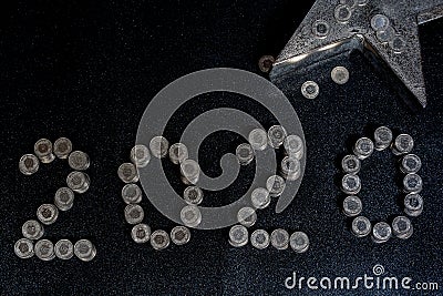 New Years 2020 graphic made from coins from Switzerland on a black shiny ground with silver star for concept Stock Photo