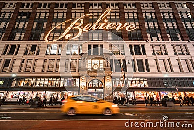 Macy`s Department Store with Christmas window display decorations and passing New York Taxi. Midtown Manhattan. New York City Editorial Stock Photo