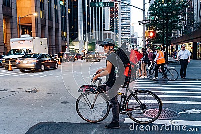Hispanic courier on bicycle in crosswalk in New York City Editorial Stock Photo