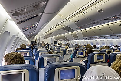New York City, USA - June 7, 2017: Interior of large passengers airplane with people on seats Editorial Stock Photo