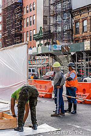 Three workers working on construction site in New York Editorial Stock Photo