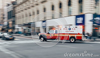 New York City, USA - March 18, 2017: FDNY Ambulance flashing lights siren blasting speed through midtown rush hour traffic in Editorial Stock Photo