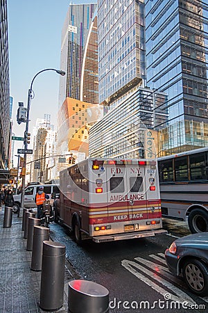 New York City, USA - March 17, 2017: FDNY Ambulance flashing lights siren blasting speed through midtown rush hour traffic in Editorial Stock Photo